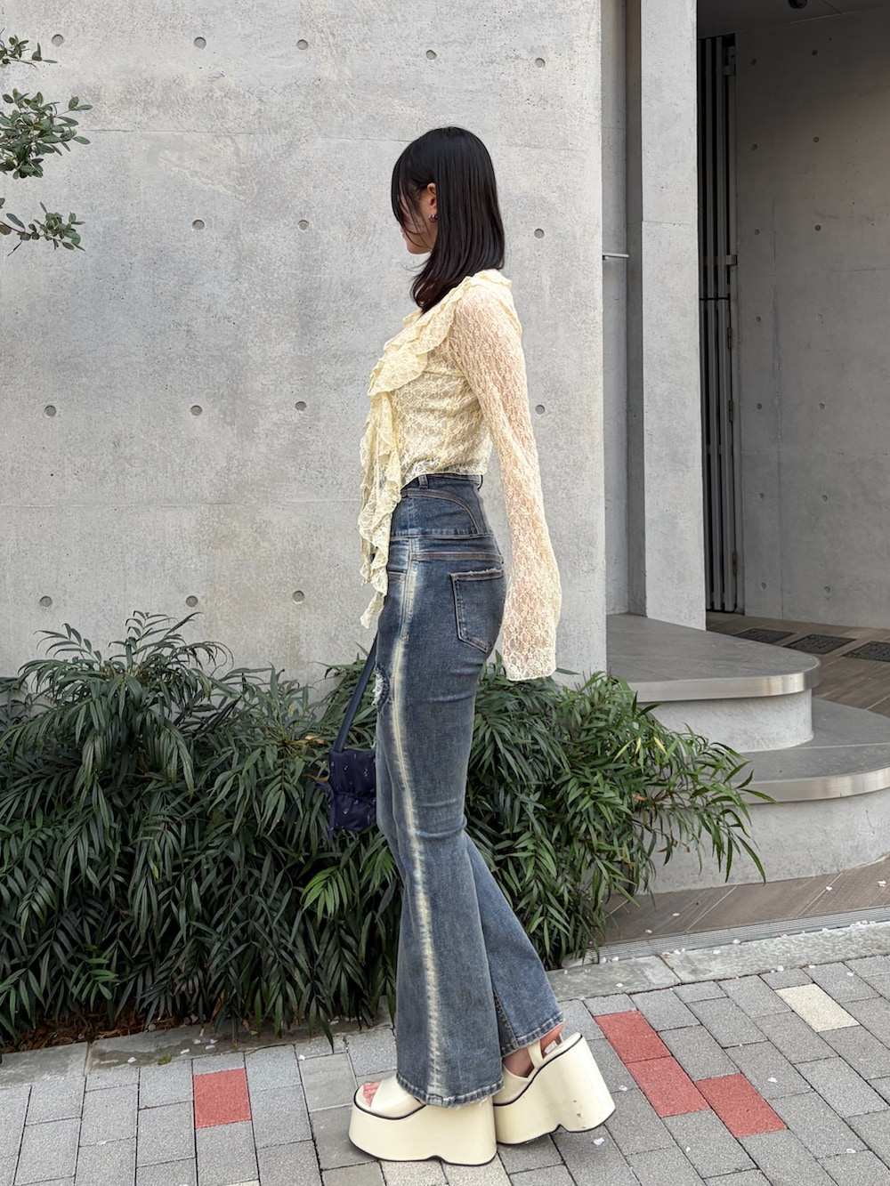 イエロー系のTシャツ/カットソー、ホワイト系のキャミソール、ブルー系のデニムパンツを着用したレディースの春コーディネートの2枚目の写真