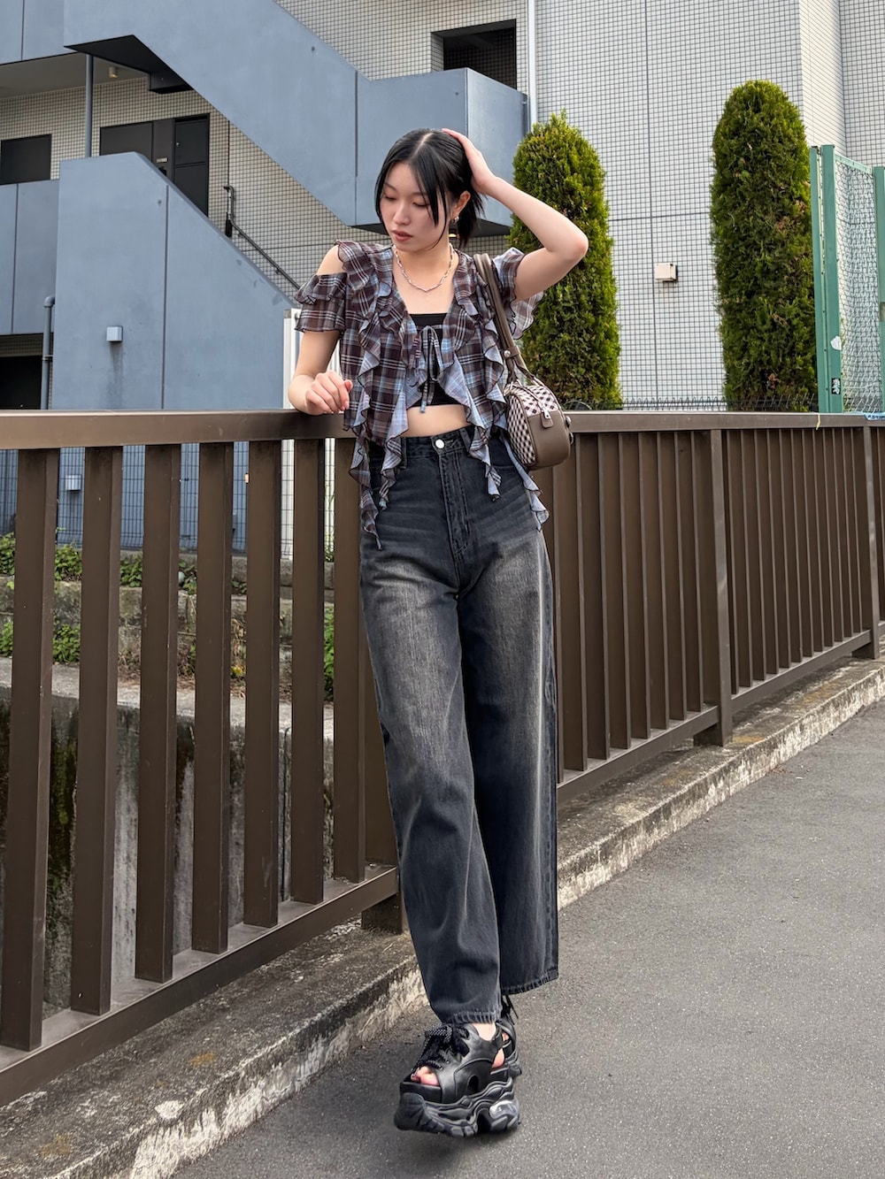 ブラック系のキャミソール、ブラウン系のTシャツ/カットソー、ブラウン系のハンドバッグを着用したレディースの春コーディネートの4枚目の写真