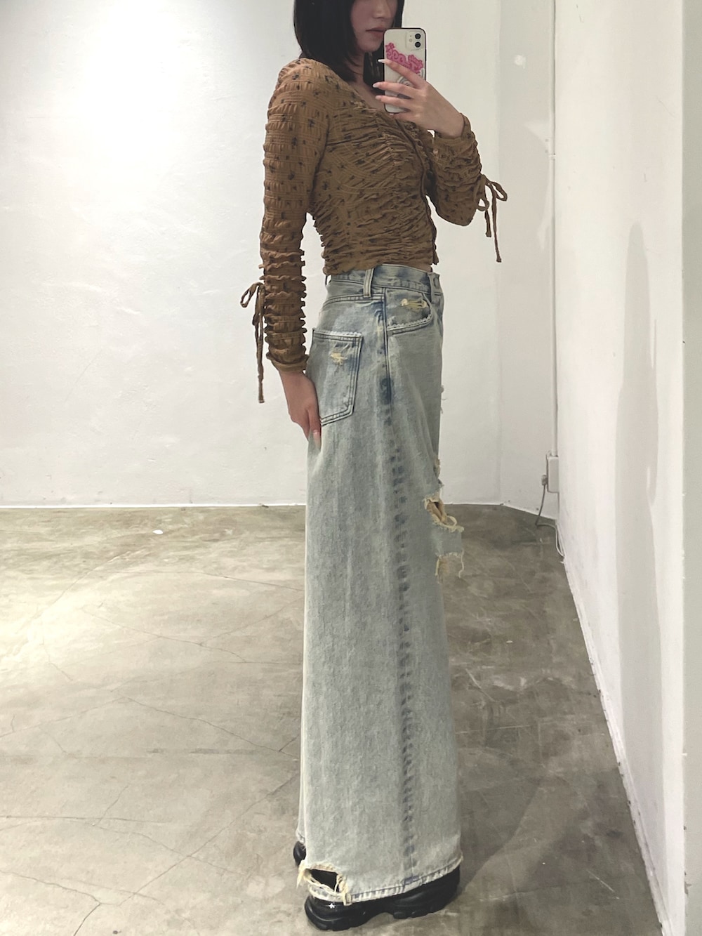 ベージュ系のTシャツ/カットソー、ブルー系のデニムパンツ、ブラック系のスニーカーを着用したレディースの冬コーディネートの2枚目の写真