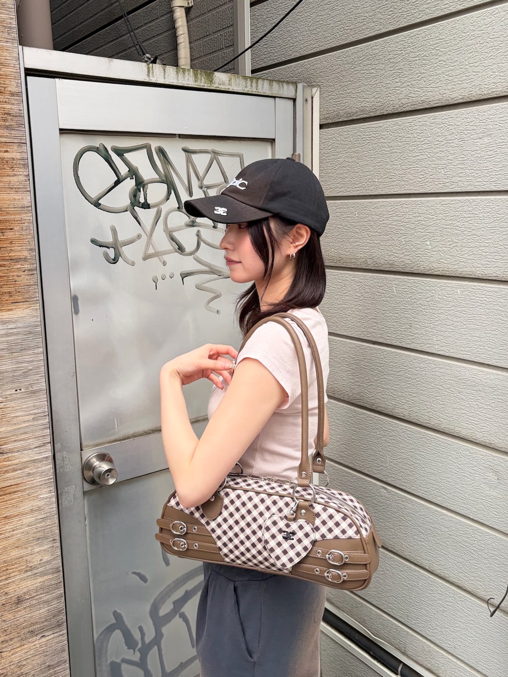 ブラウン系のハンドバッグ、ピンク系のTシャツ/カットソー、ブルー系のスウェットパンツを着用したレディースの春コーディネートの5枚目の写真