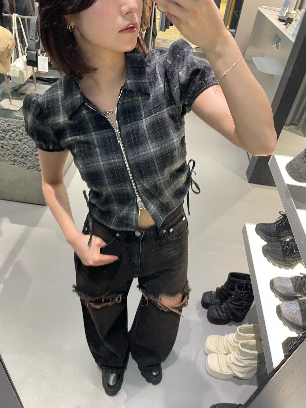 ブラック系のTシャツ/カットソー、ブラック系のデニムパンツ、ブラック系のブーツを着用したレディースの夏コーディネートの4枚目の写真