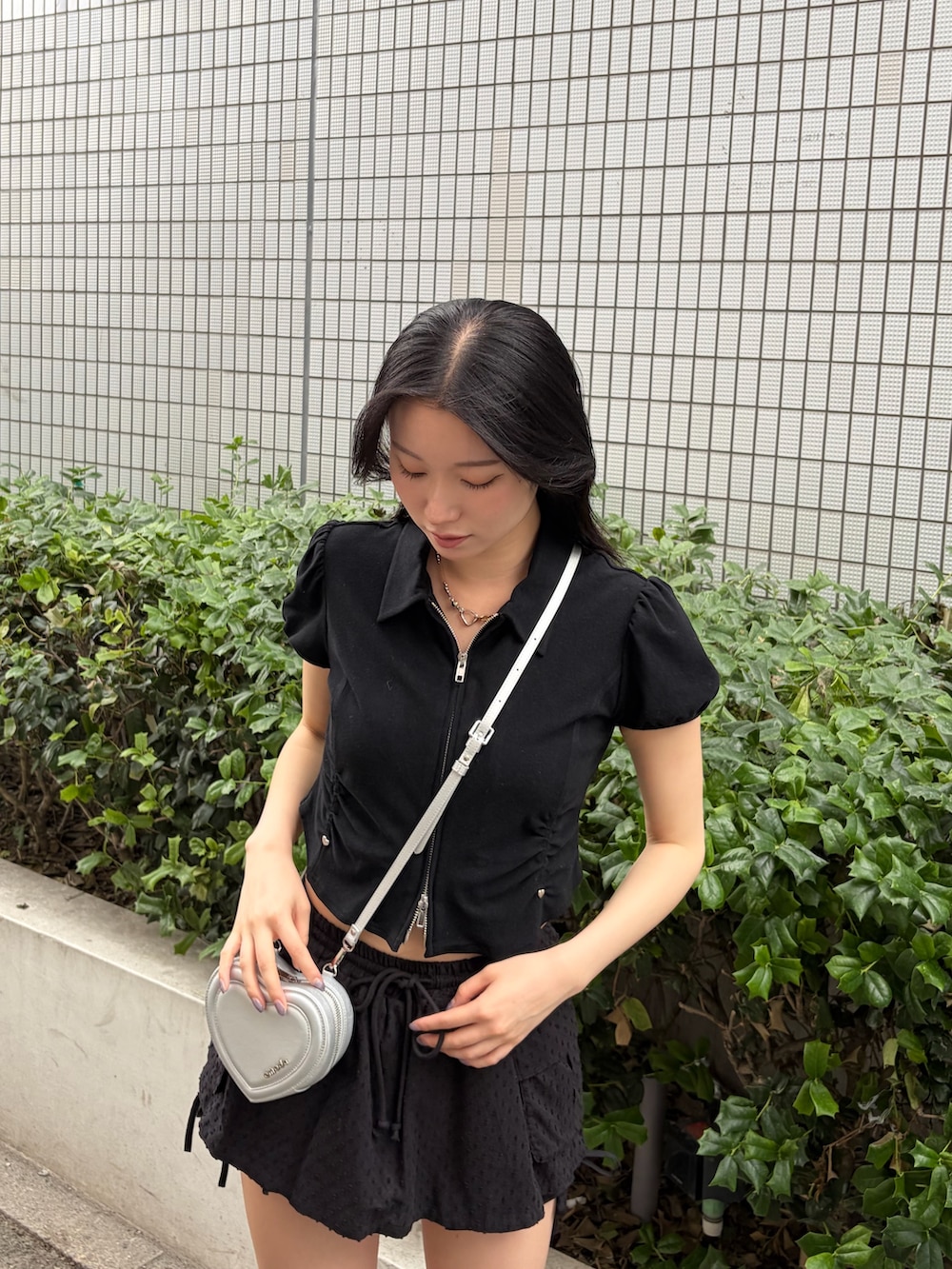 ブラック系のシャツ/ブラウス、ブラック系のスカート、シルバー系のショルダーバッグを着用したレディースの夏コーディネートの6枚目の写真