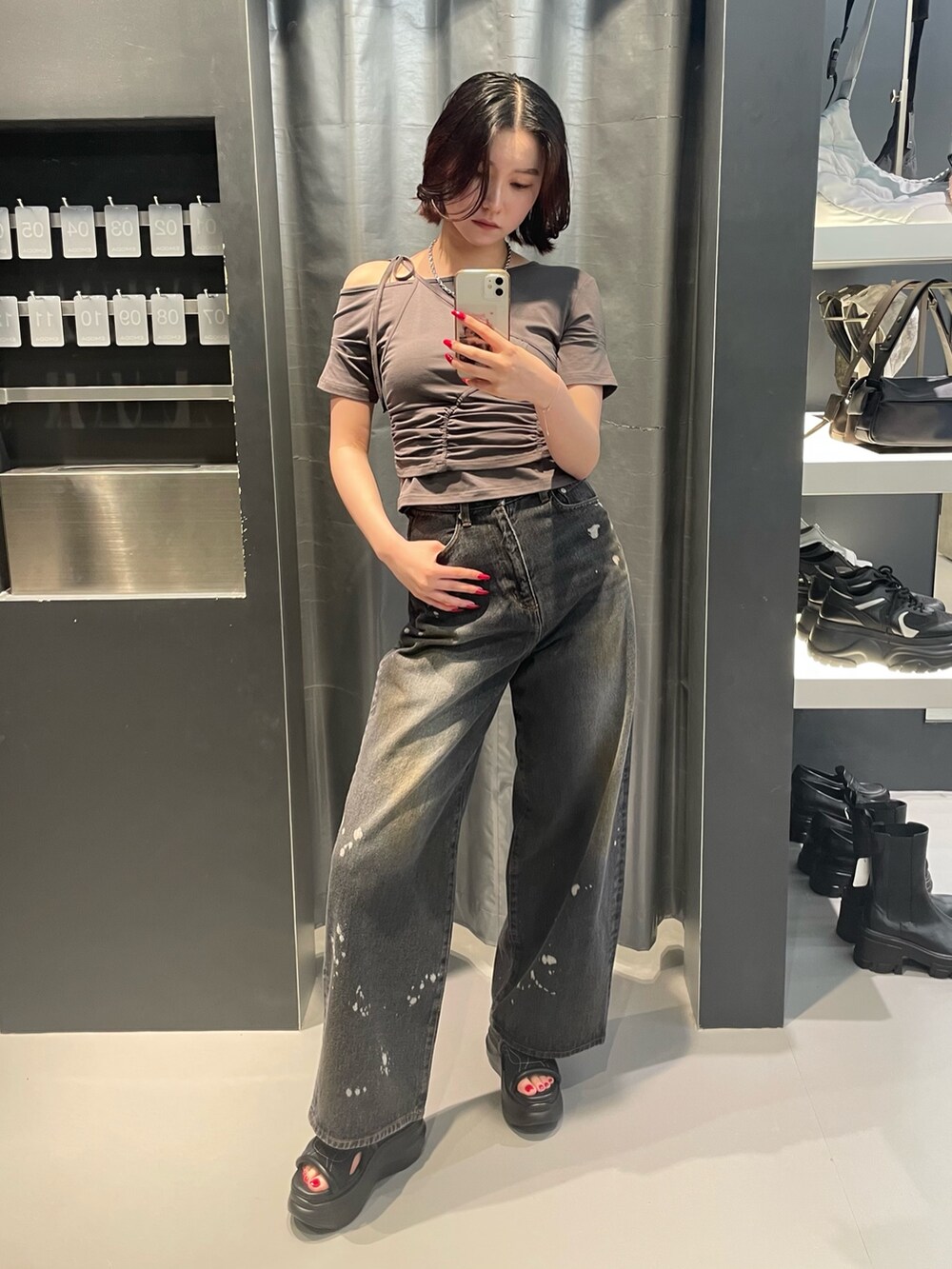 グレー系のTシャツ/カットソー、ブラック系のデニムパンツ、ブラック系のサンダルを着用したレディースの春コーディネートの2枚目の写真