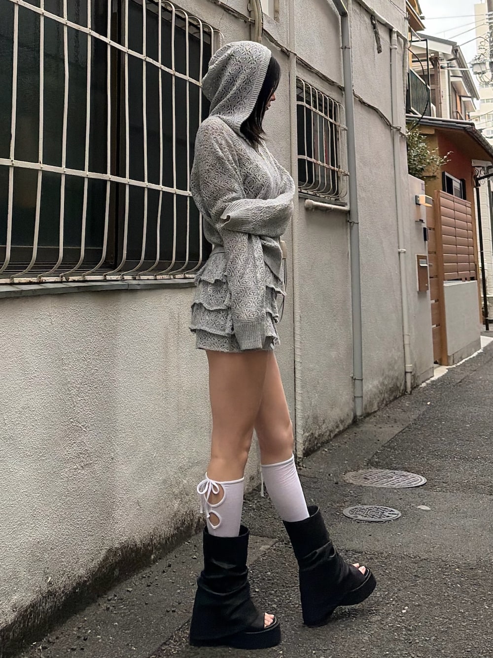 グレー系のパーカー、グレー系のスカート、ブラック系のサンダルを着用したレディースの春コーディネートの4枚目の写真