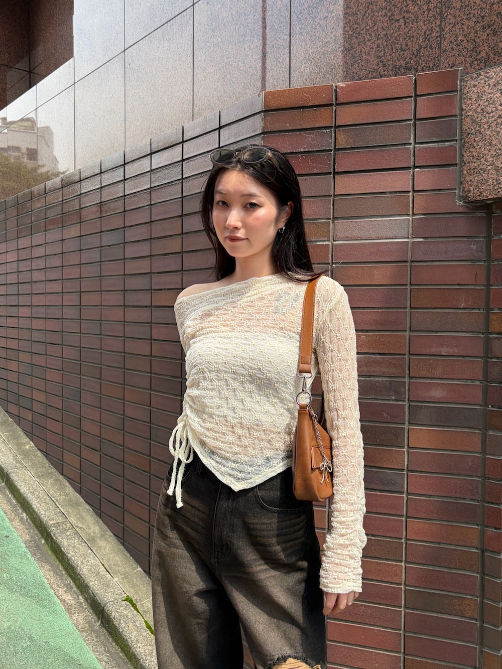 ブラウン系のショルダーバッグ、ホワイト系のTシャツ/カットソー、ブラック系のデニムパンツを着用したレディースの秋コーディネートの5枚目の写真