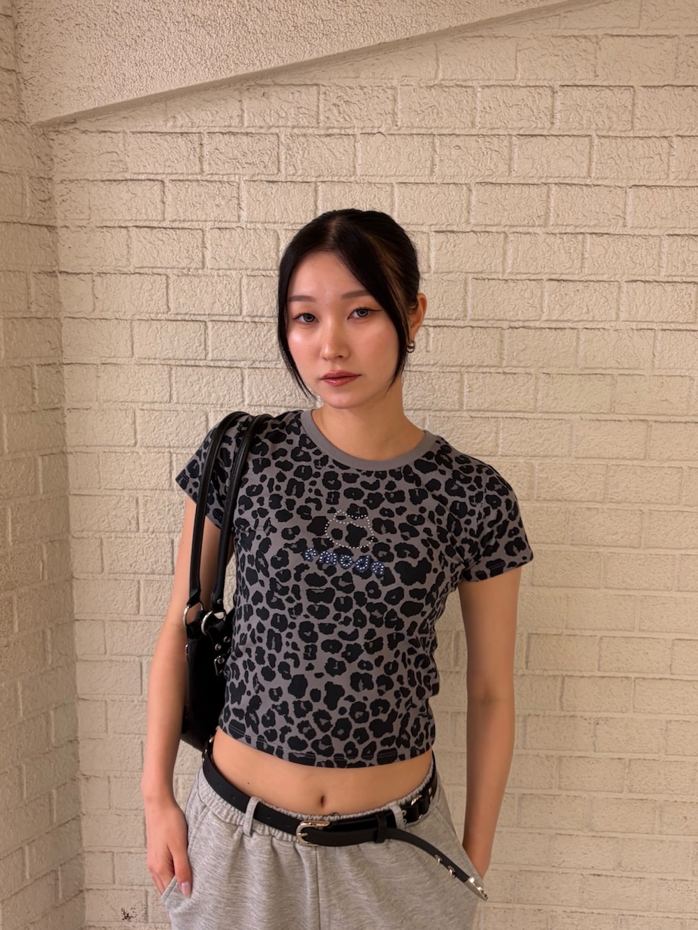 グレー系のTシャツ/カットソー、グレー系のスウェットパンツ、ブラック系のショルダーバッグを着用したレディースの夏コーディネートの5枚目の写真