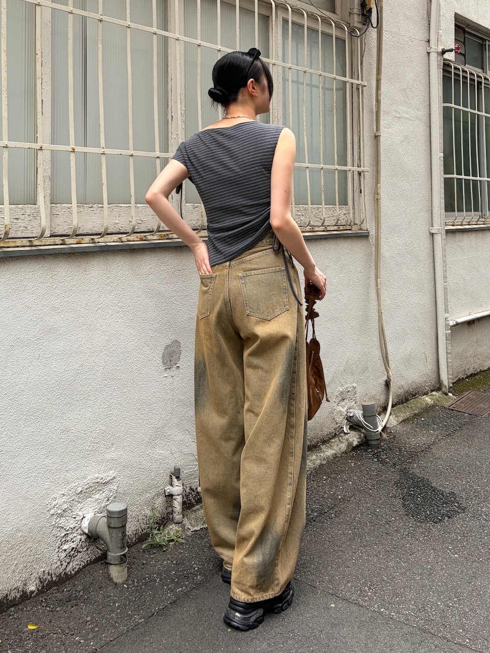 グレー系のTシャツ/カットソー、ブラウン系のショルダーバッグ、ベージュ系のデニムパンツを着用したレディースの夏コーディネートの3枚目の写真