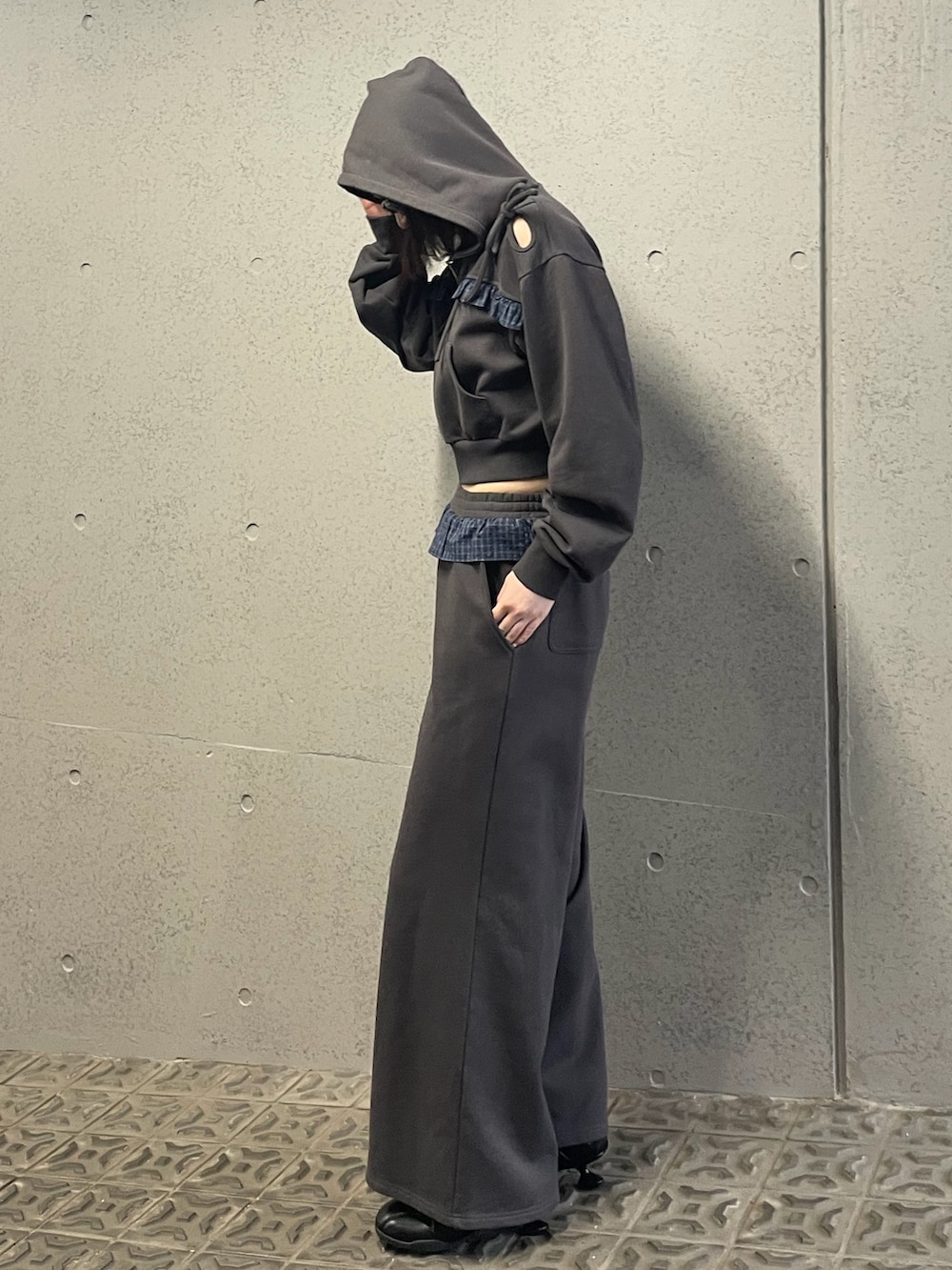 グレー系のパーカー、グレー系のスウェットパンツ、ブラック系のスニーカーを着用したレディースの冬コーディネートの3枚目の写真