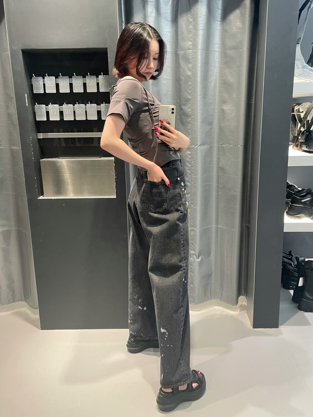 グレー系のTシャツ/カットソー、ブラック系のデニムパンツ、ブラック系のサンダルを着用したレディースの春コーディネートの3枚目の写真