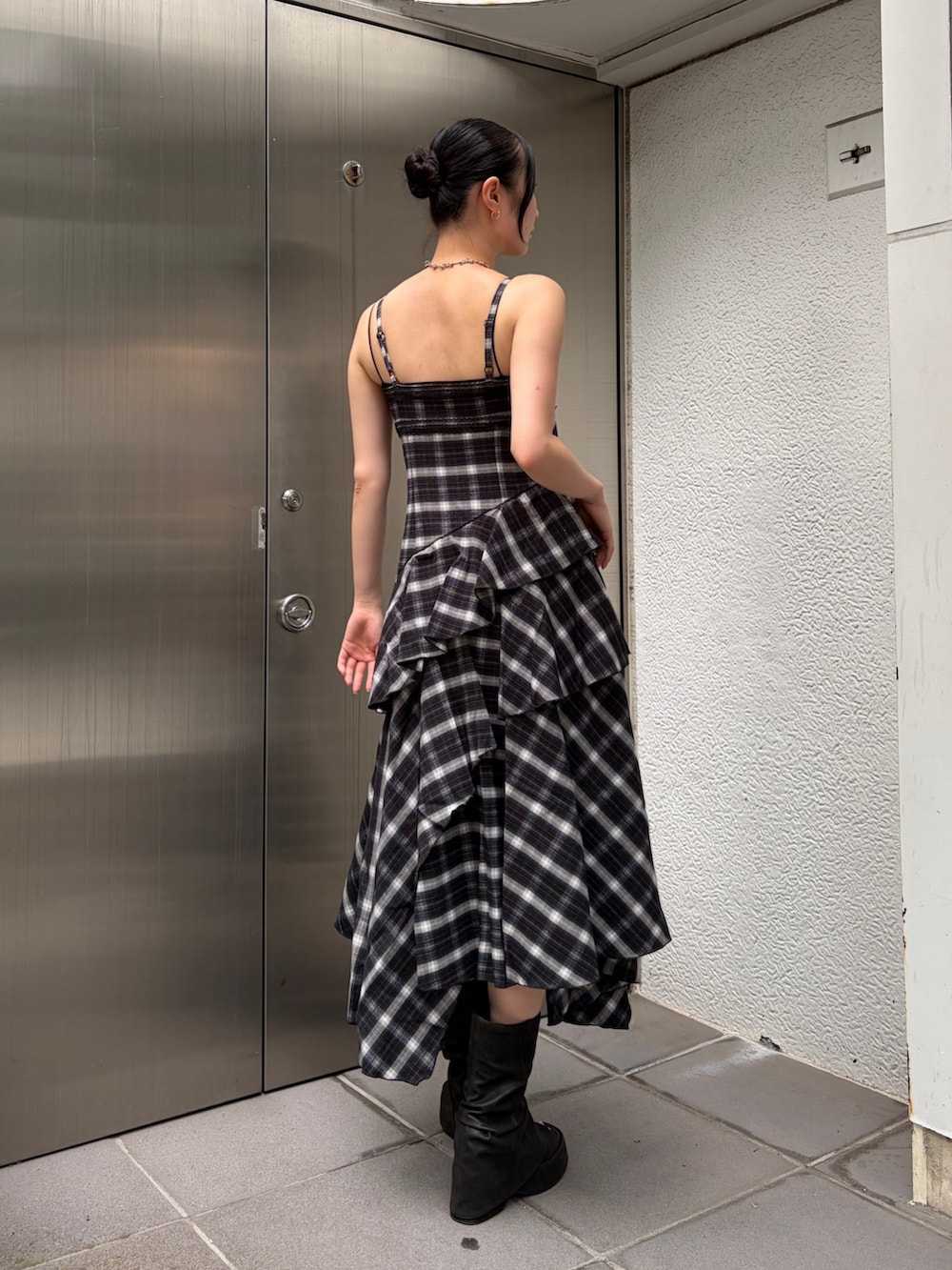ブラック系のワンピース、ブラック系のサンダル、シルバー系のピアス(両耳用)を着用したレディースの夏コーディネートの3枚目の写真