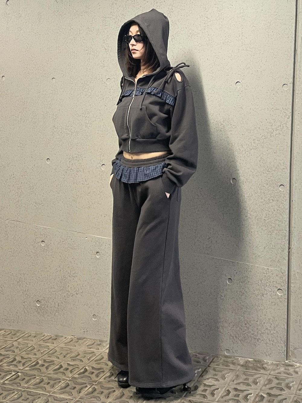 グレー系のパーカー、グレー系のスウェットパンツ、ブラック系のスニーカーを着用したレディースの冬コーディネートの2枚目の写真