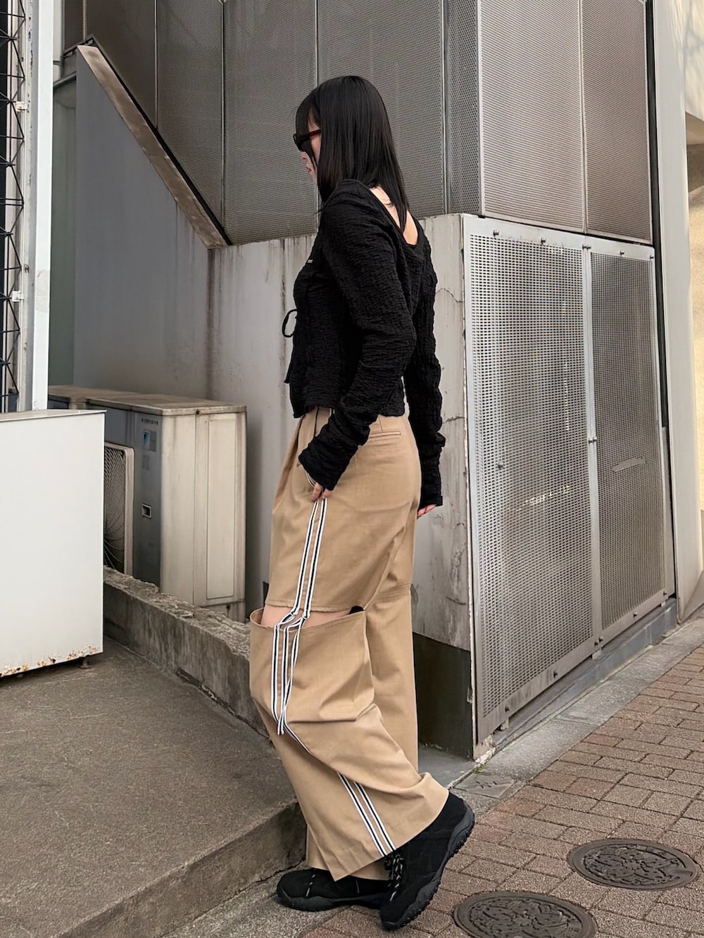 ブラック系のTシャツ/カットソー、ベージュ系のその他パンツ、ブラック系のスニーカーを着用したレディースの春コーディネートの3枚目の写真