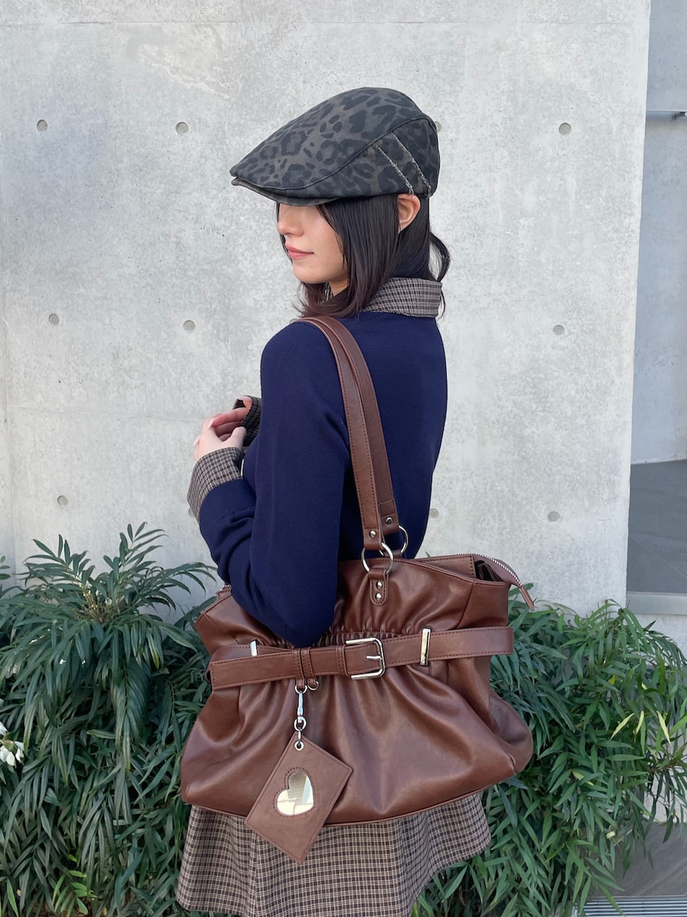 ブルー系のスカート、ブラック系のトートバッグ、ブラウン系のブーツを着用したレディースの冬コーディネートの6枚目の写真