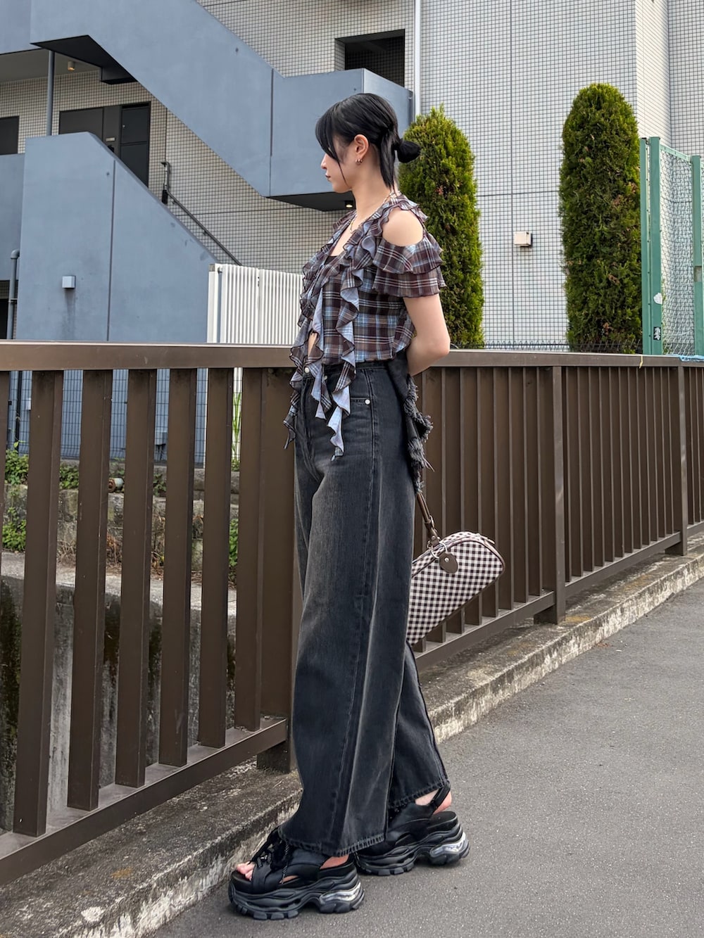 ブラック系のキャミソール、ブラウン系のTシャツ/カットソー、ブラウン系のハンドバッグを着用したレディースの春コーディネートの2枚目の写真