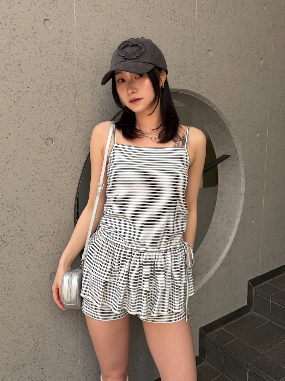 ホワイト系のキャミソール、ホワイト系のその他パンツ、ブラック系のブーツを着用したレディースの夏コーディネートの4枚目の写真