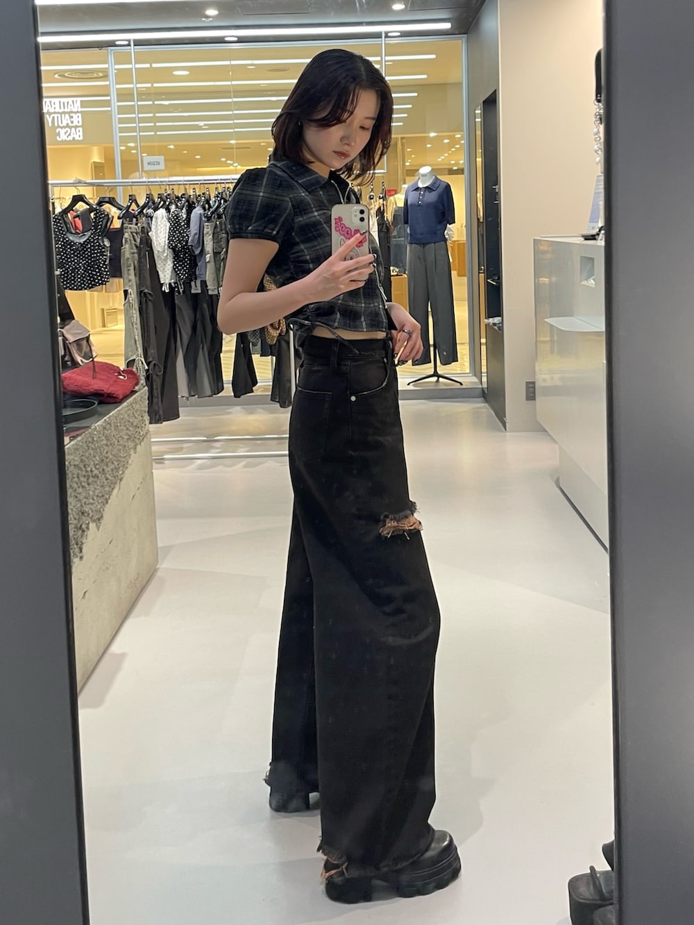 ブラック系のTシャツ/カットソー、ブラック系のデニムパンツ、ブラック系のブーツを着用したレディースの夏コーディネートの2枚目の写真