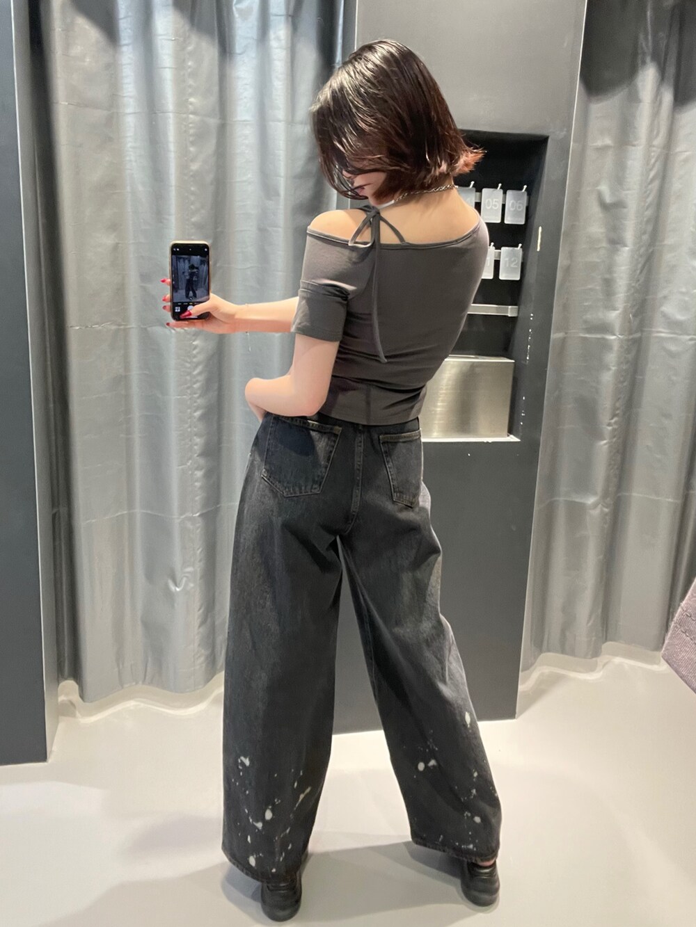 グレー系のTシャツ/カットソー、ブラック系のデニムパンツ、ブラック系のサンダルを着用したレディースの春コーディネートの4枚目の写真