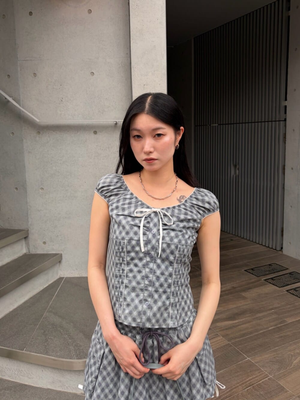 ブラック系のサンダル、ブルー系のハンドバッグ、ブルー系のシャツ/ブラウスを着用したレディースの夏コーディネートの5枚目の写真