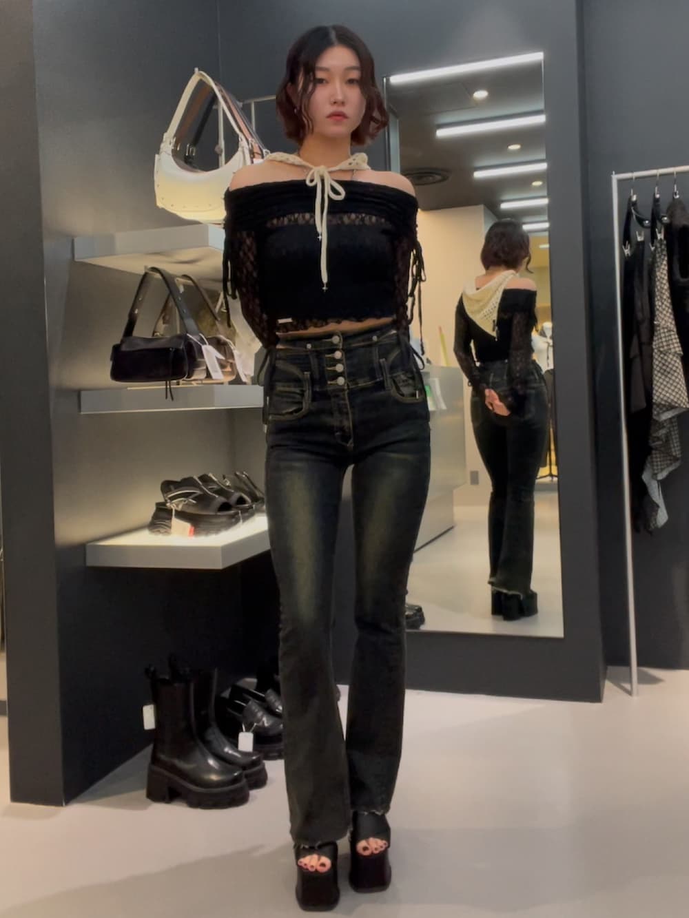 ブラック系のTシャツ/カットソー、ブルー系のデニムパンツ、ブラック系のサンダルを着用したレディースの春コーディネートの4枚目の写真