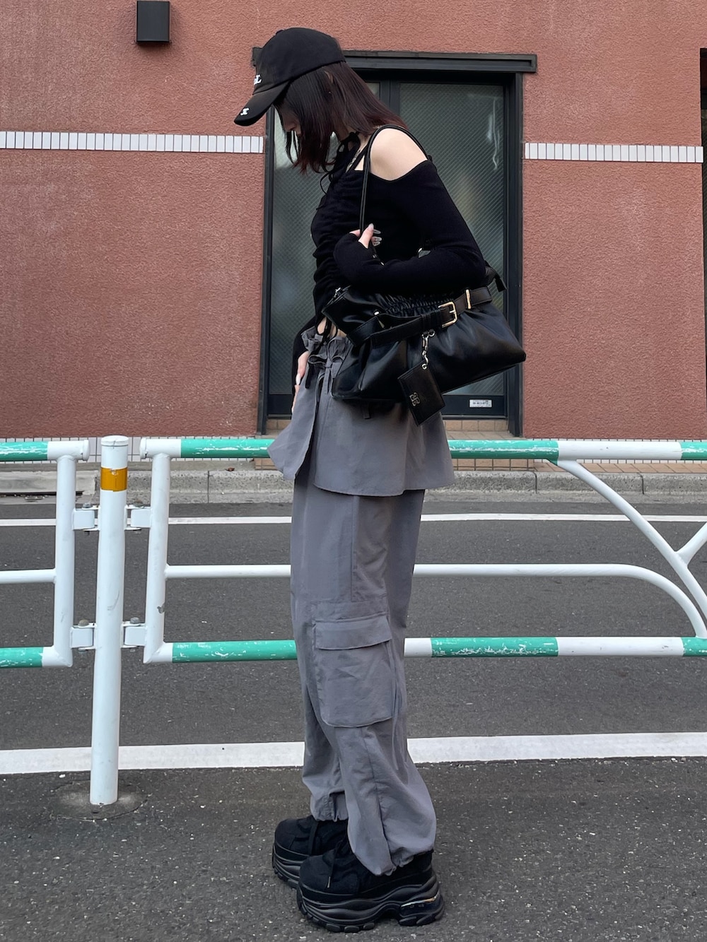 ブラック系のニット/セーター、グレー系のその他パンツ、ブラック系のトートバッグを着用したレディースの冬コーディネートの2枚目の写真