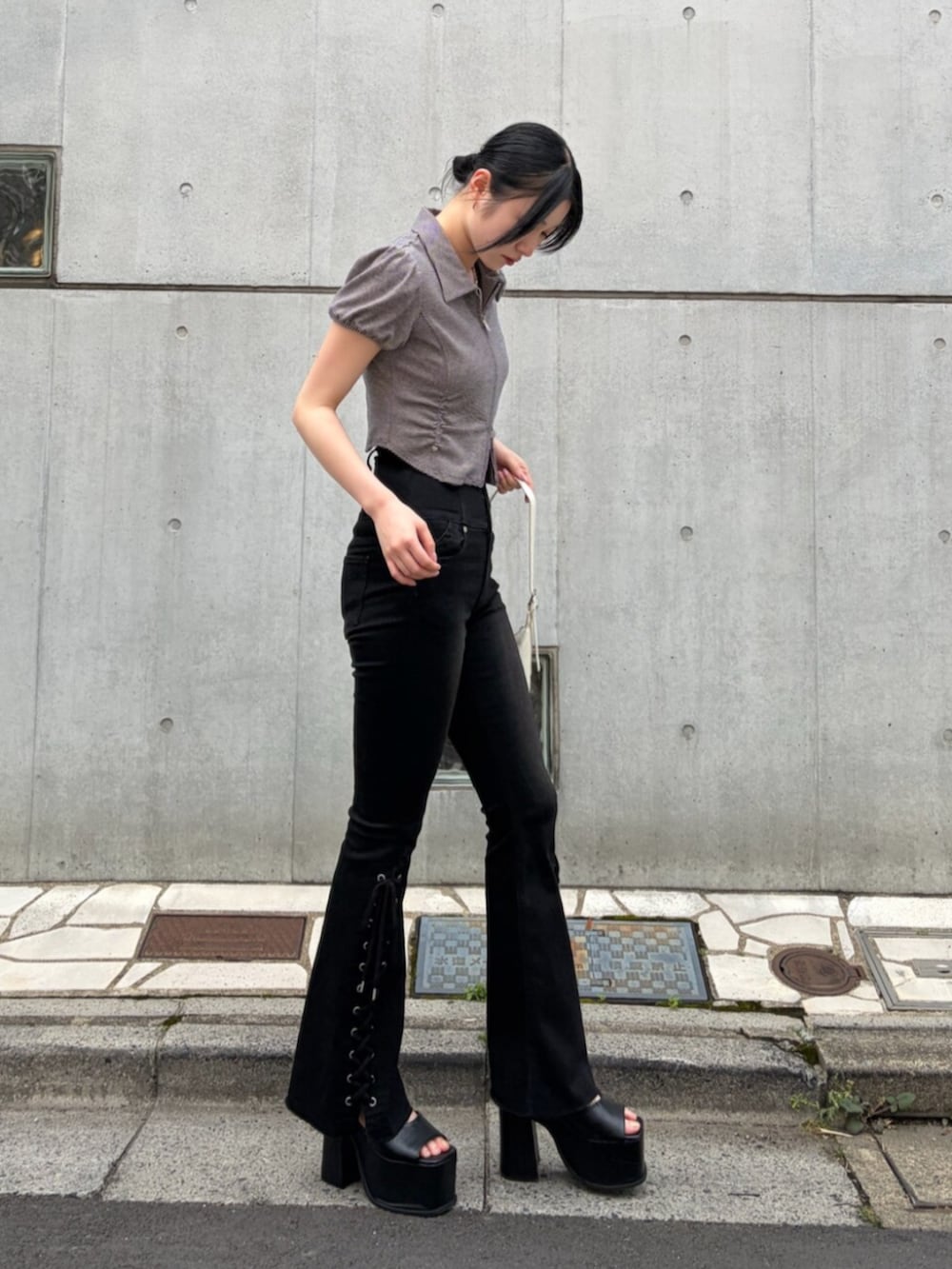 ブラック系のサンダル、ブルー系のシャツ/ブラウス、ホワイト系のハンドバッグを着用したレディースの夏コーディネートの4枚目の写真