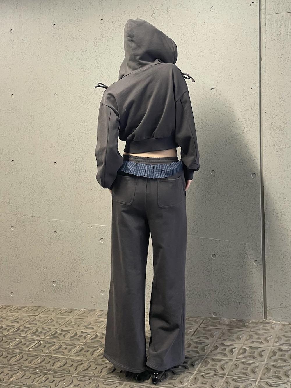 グレー系のパーカー、グレー系のスウェットパンツ、ブラック系のスニーカーを着用したレディースの冬コーディネートの4枚目の写真