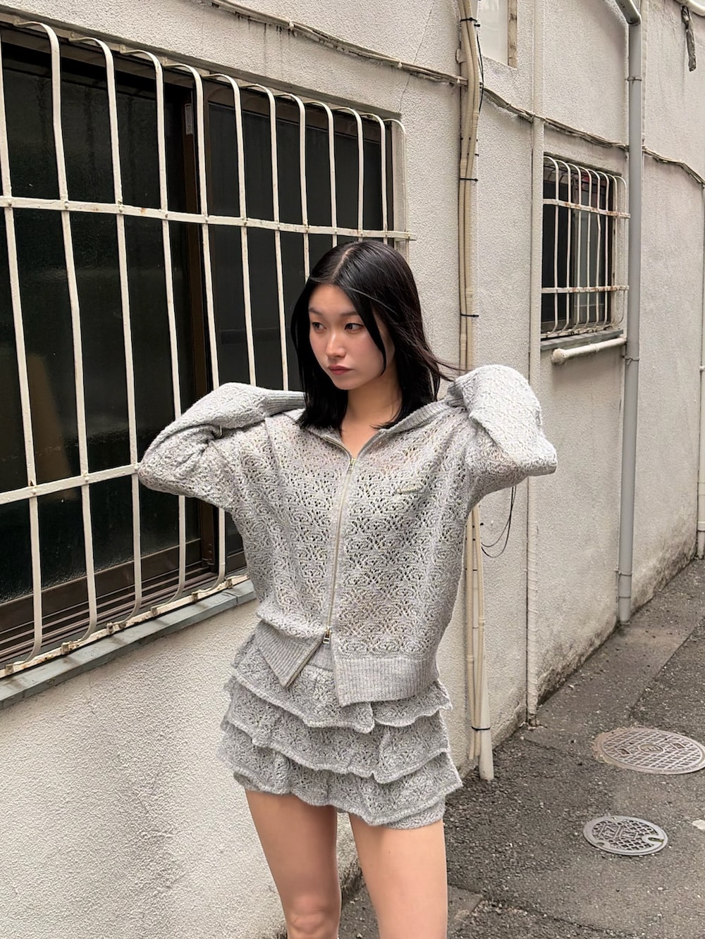 グレー系のパーカー、グレー系のスカート、ブラック系のサンダルを着用したレディースの春コーディネートの6枚目の写真