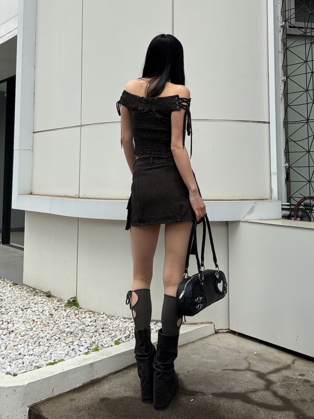 ブラック系のハンドバッグ、ブラウン系のTシャツ/カットソー、ブラウン系のスカートを着用したレディースの春コーディネートの3枚目の写真