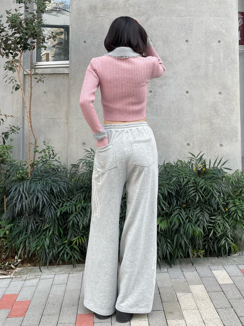 ピンク系のニット/セーター、グレー系のスウェットパンツ、ブラック系のブーツを着用したレディースの冬コーディネートの4枚目の写真