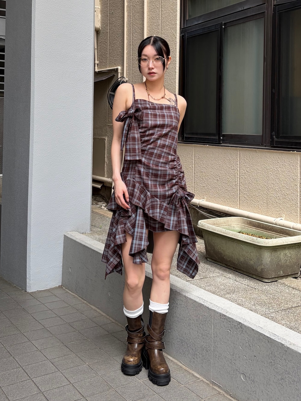 ブラウン系のワンピース、ブラウン系のブーツ、シルバー系のサングラスを着用したレディースの夏コーディネートの4枚目の写真