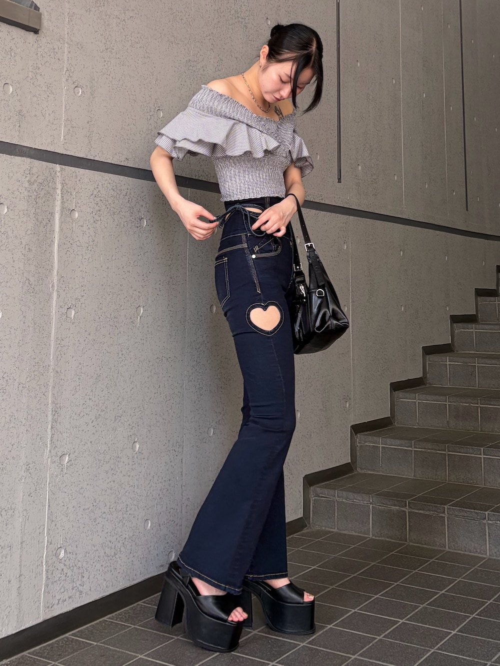 グレー系のTシャツ/カットソー、ブルー系のデニムパンツ、ブラック系のハンドバッグを着用したレディースの夏コーディネートの2枚目の写真
