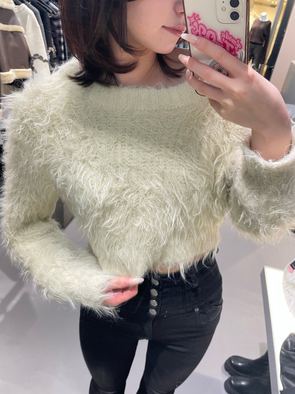 ホワイト系のニット/セーター、ブラック系のデニムパンツ、ブラック系のブーツを着用したレディースの冬コーディネートの5枚目の写真