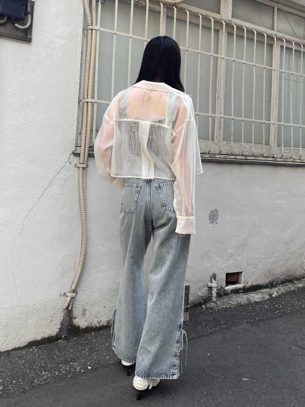 ブルー系のタンクトップ、ブルー系のデニムパンツ、ホワイト系のスニーカーを着用したレディースの春コーディネートの3枚目の写真