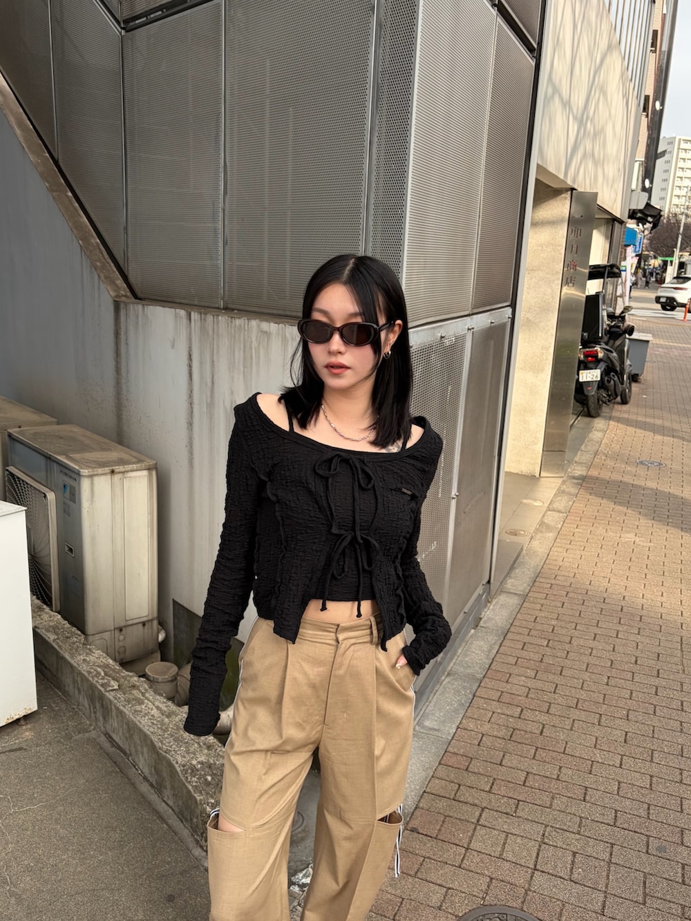 ブラック系のTシャツ/カットソー、ベージュ系のその他パンツ、ブラック系のスニーカーを着用したレディースの春コーディネートの5枚目の写真