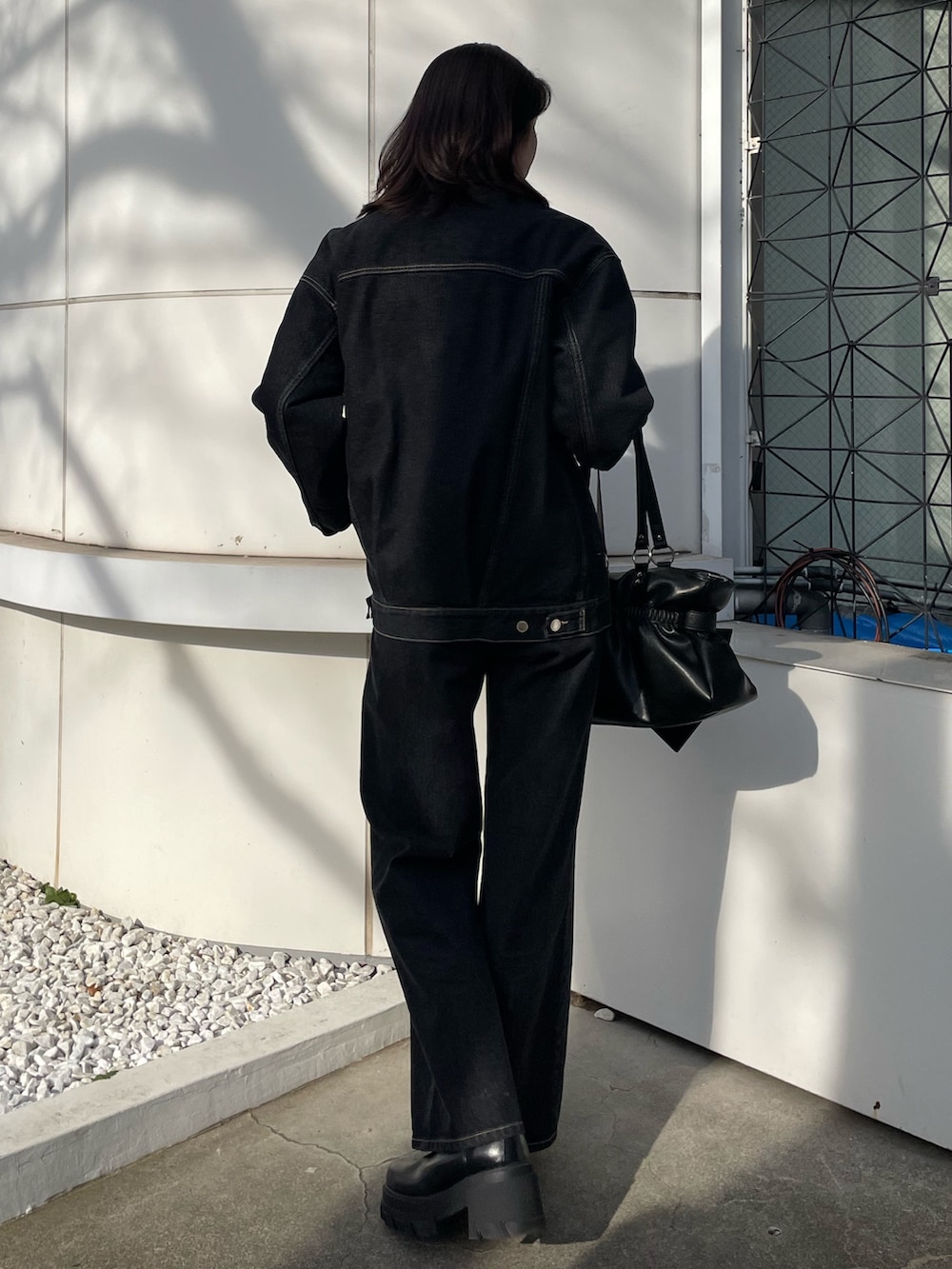 ブラック系のニット/セーター、ブルー系のブルゾン、ブルー系のデニムパンツを着用したレディースの冬コーディネートの3枚目の写真