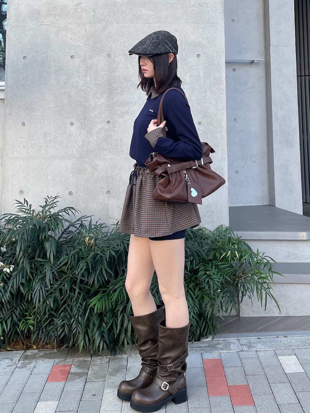ブルー系のスカート、ブラック系のトートバッグ、ブラウン系のブーツを着用したレディースの冬コーディネートの3枚目の写真