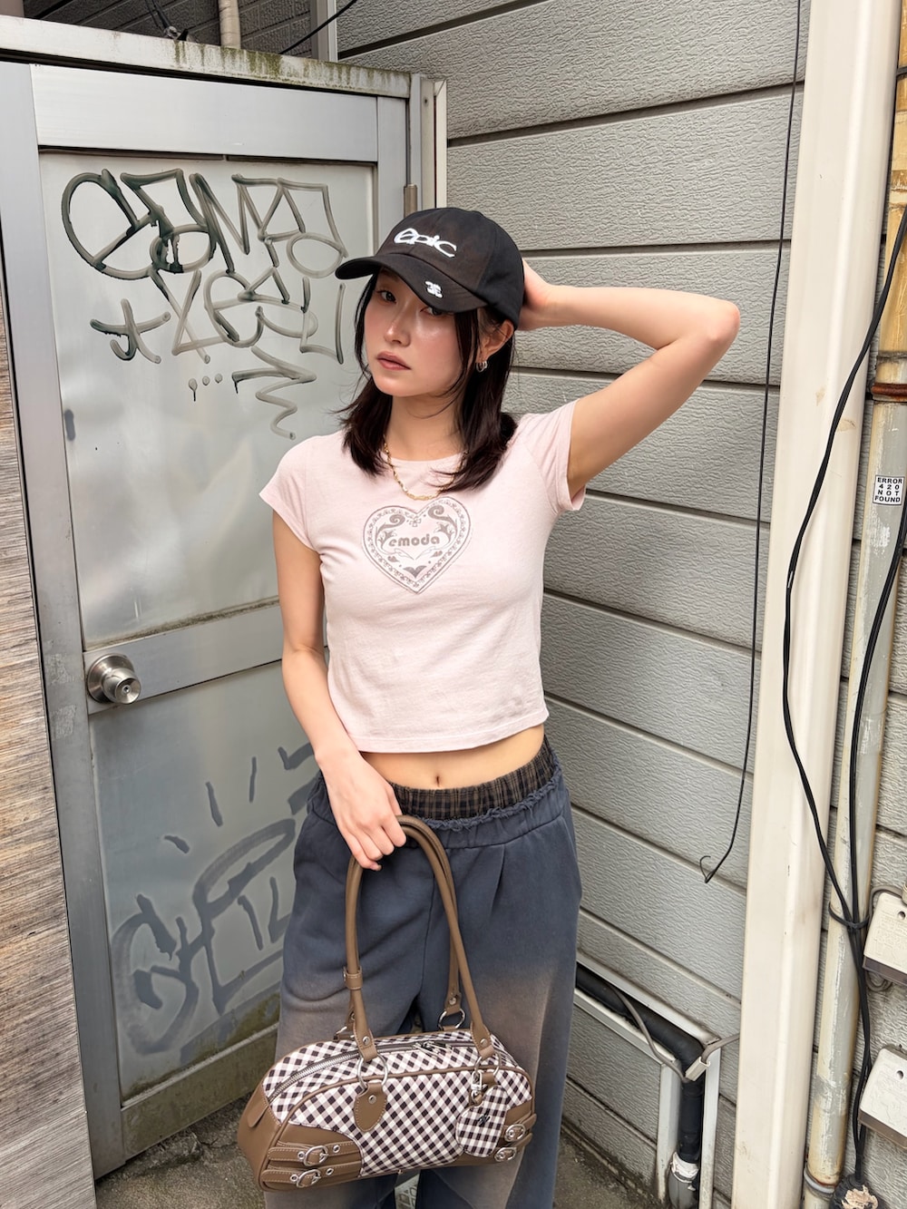 ブラウン系のハンドバッグ、ピンク系のTシャツ/カットソー、ブルー系のスウェットパンツを着用したレディースの春コーディネートの6枚目の写真