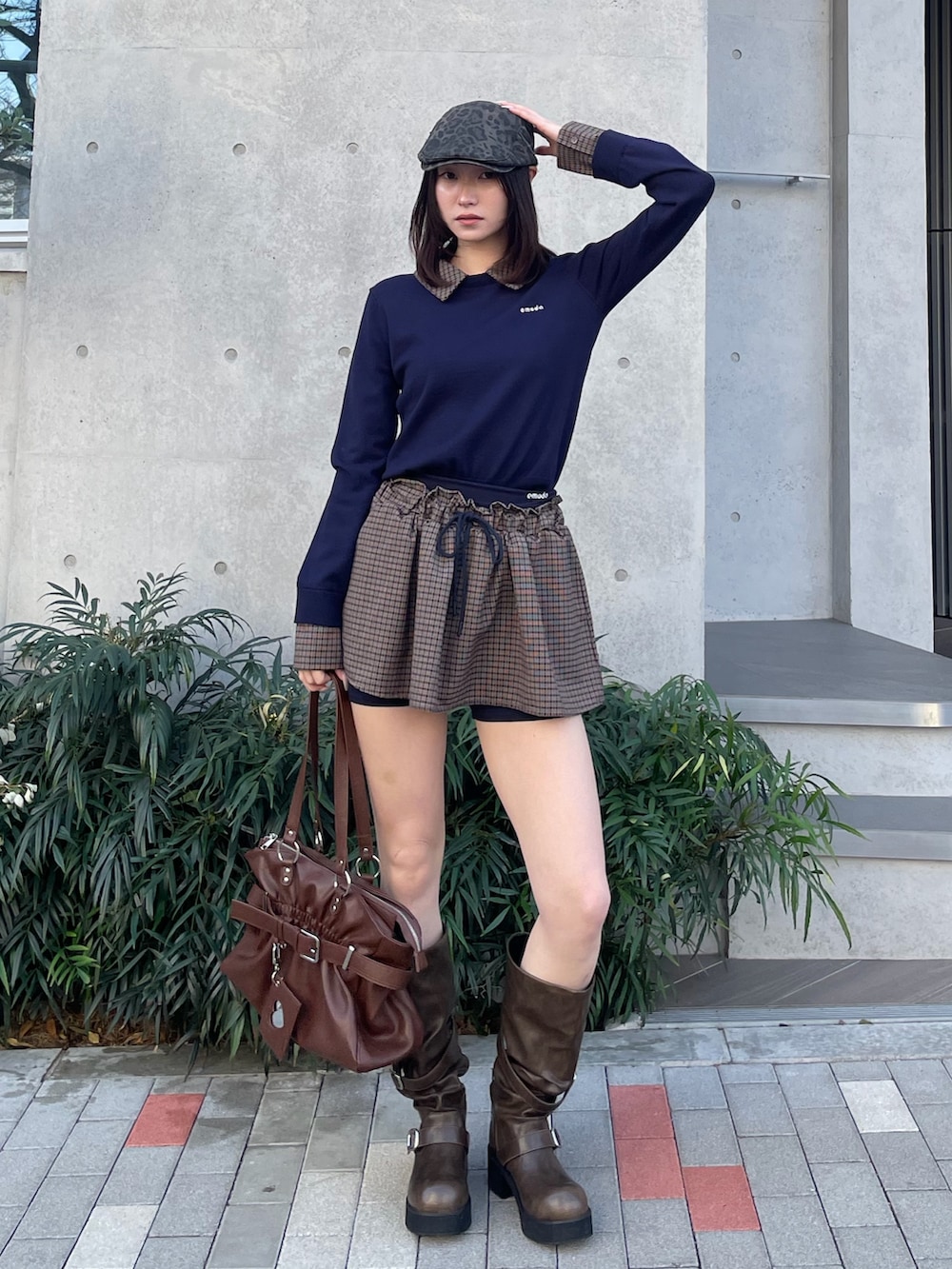 ブルー系のスカート、ブラック系のトートバッグ、ブラウン系のブーツを着用したレディースの冬コーディネートの2枚目の写真