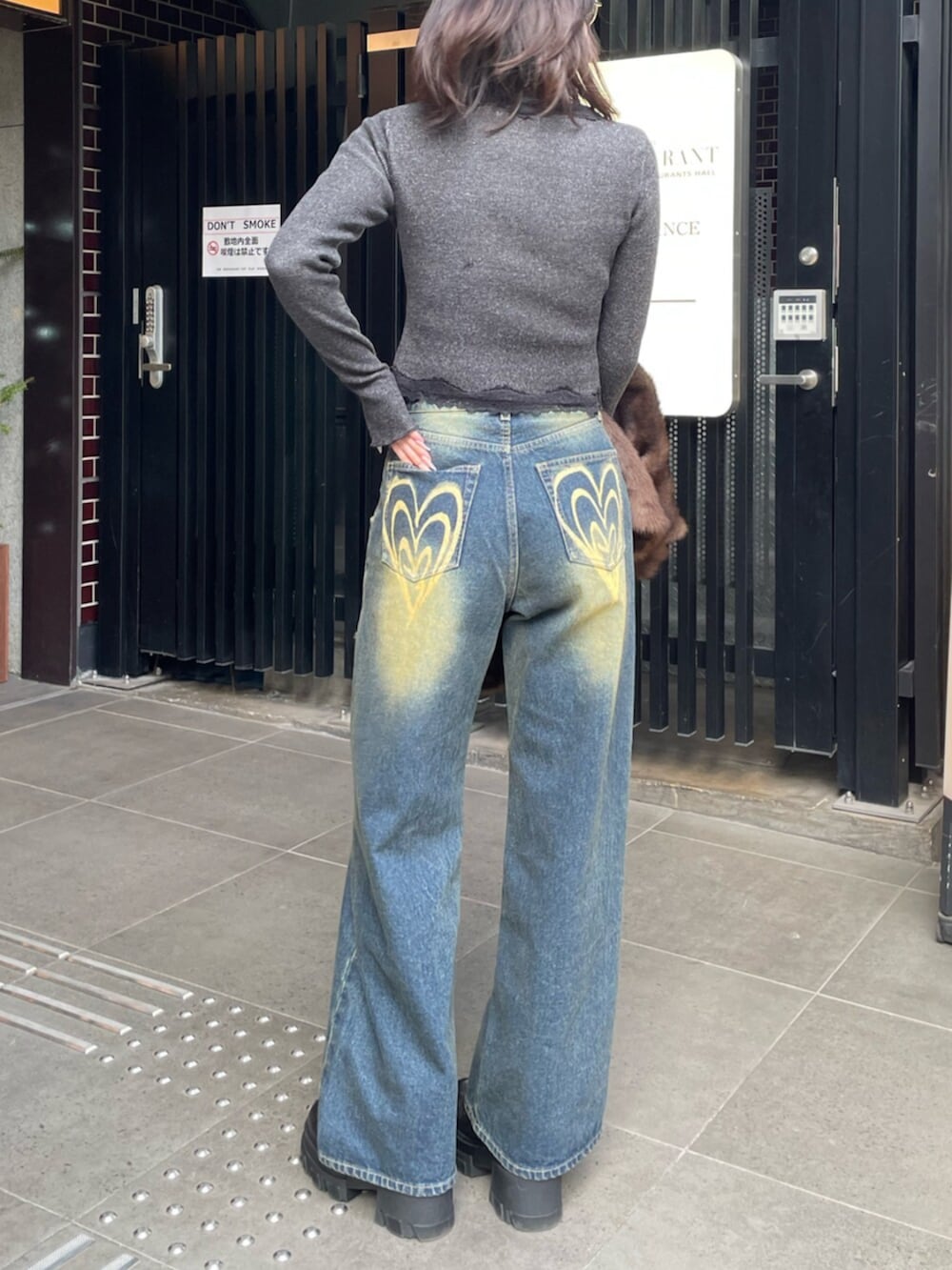 ブラック系のブーツ、ブラック系のニット/セーター、ブルー系のデニムパンツを着用したレディースの冬コーディネートの3枚目の写真