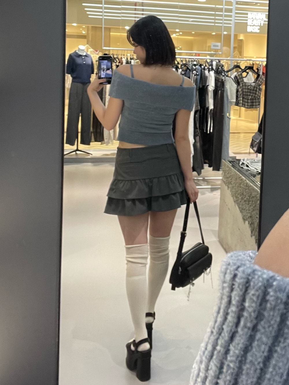 ブルー系のニット/セーター、グレー系のスカート、ブラック系のサンダルを着用したレディースの夏コーディネートの3枚目の写真