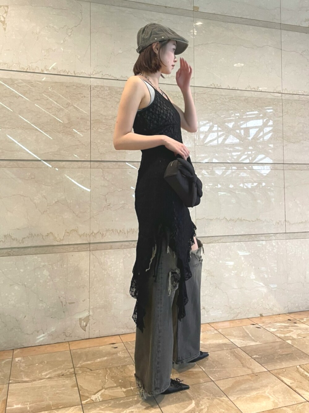 グレー系のニット/セーター、ブラック系のワンピース、ブラック系のデニムパンツを着用したレディースの夏コーディネートの2枚目の写真