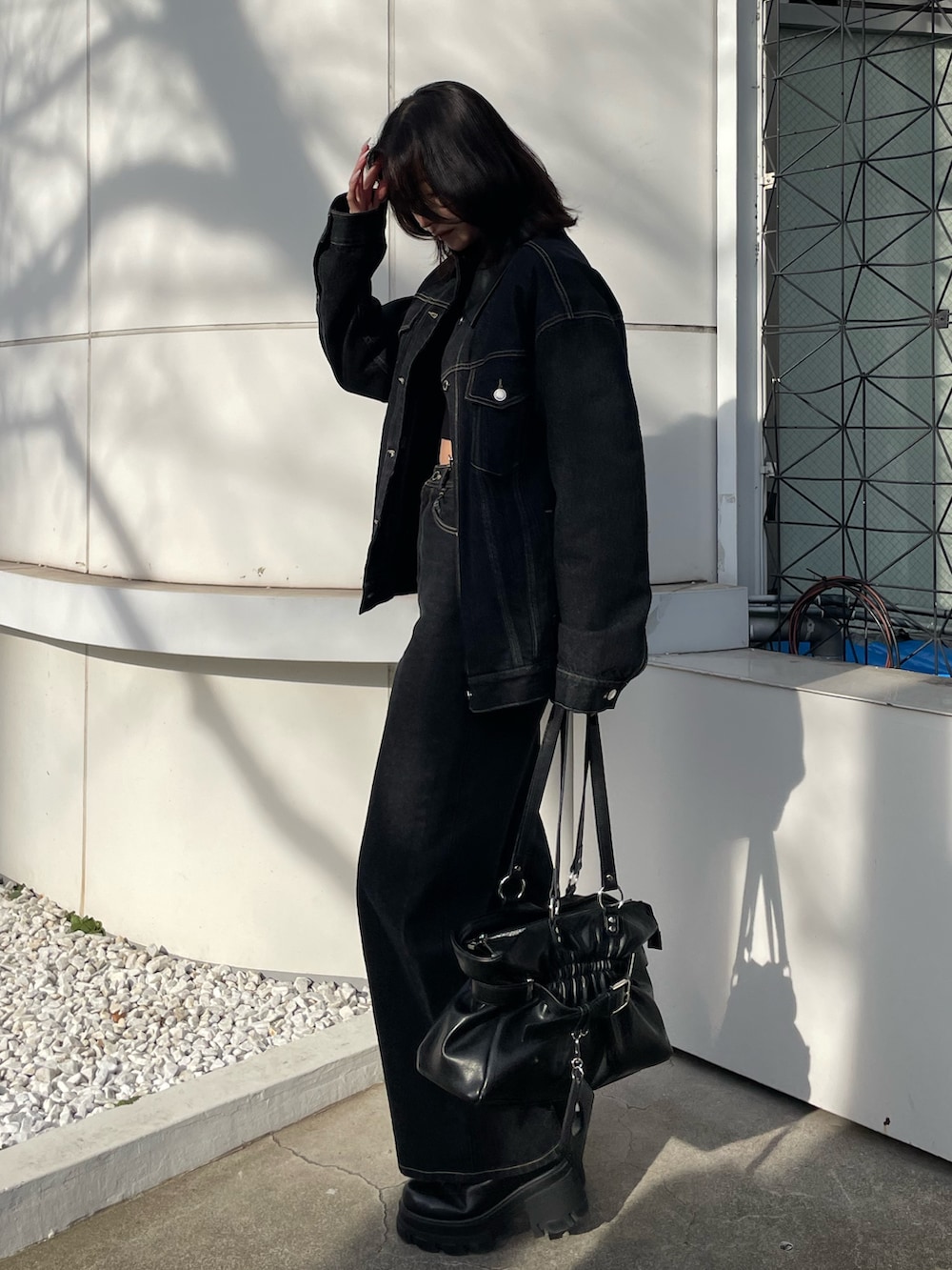 ブラック系のニット/セーター、ブルー系のブルゾン、ブルー系のデニムパンツを着用したレディースの冬コーディネートの2枚目の写真