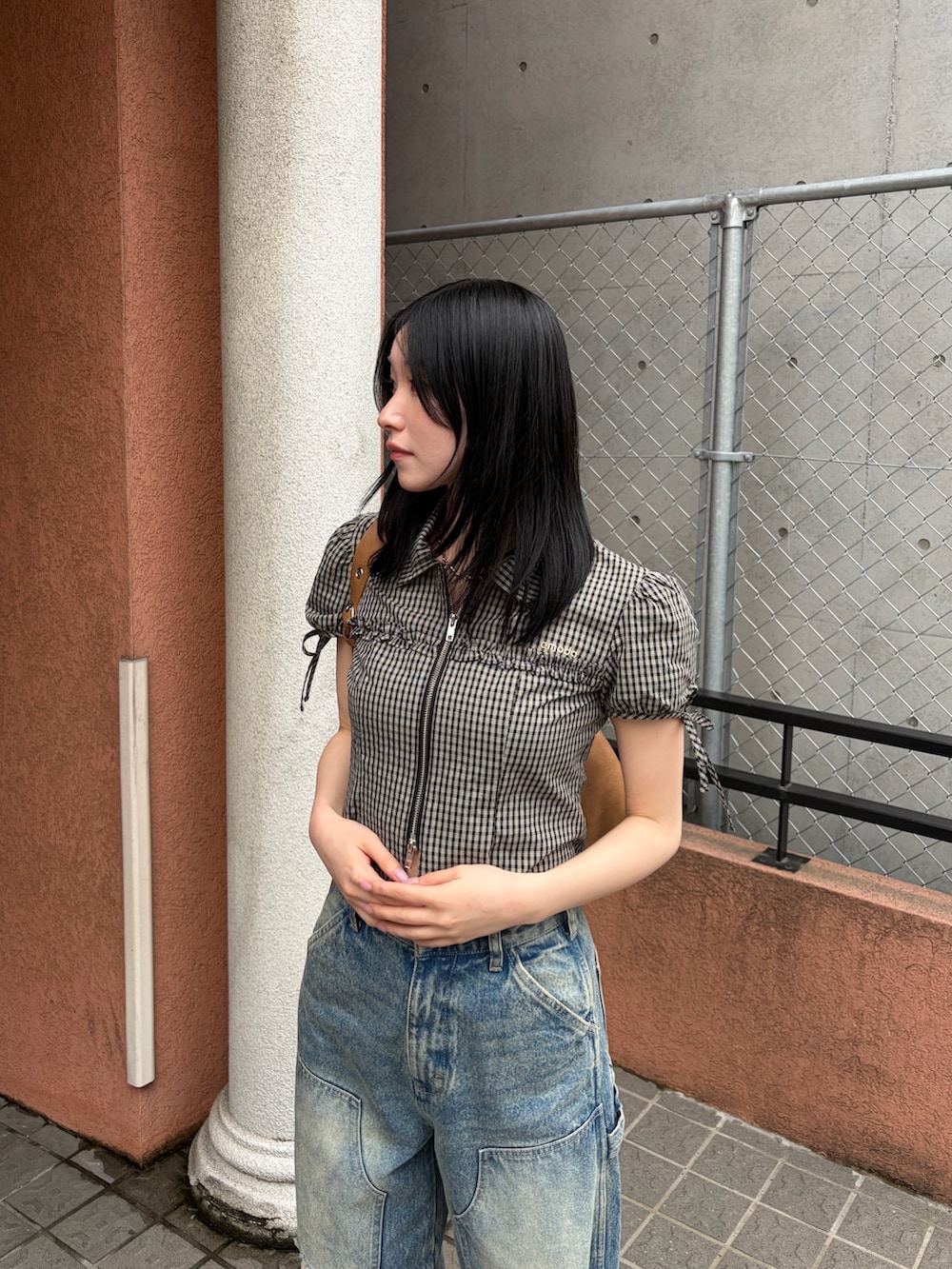ブラック系のシャツ/ブラウス、ブラック系のサンダル、ブルー系のデニムパンツを着用したレディースの春コーディネートの5枚目の写真