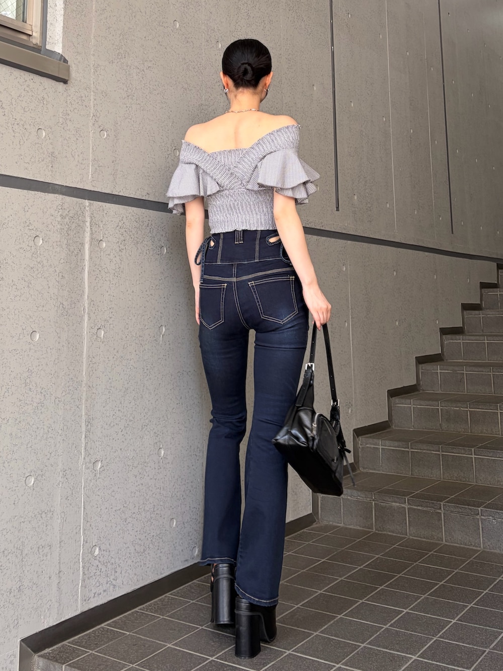 グレー系のTシャツ/カットソー、ブルー系のデニムパンツ、ブラック系のハンドバッグを着用したレディースの夏コーディネートの3枚目の写真