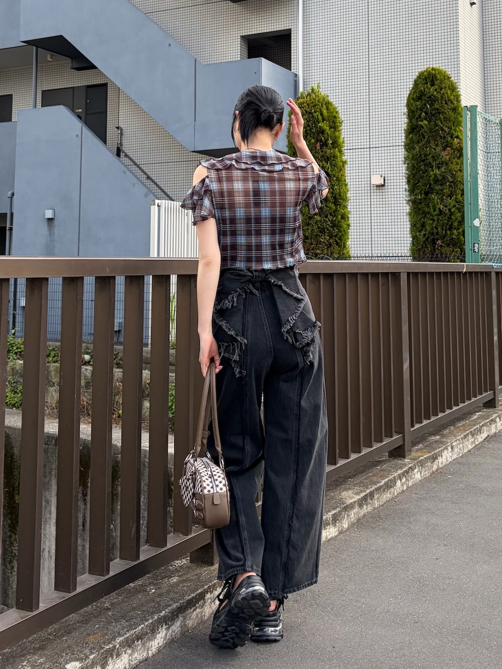 ブラック系のキャミソール、ブラウン系のTシャツ/カットソー、ブラウン系のハンドバッグを着用したレディースの春コーディネートの3枚目の写真