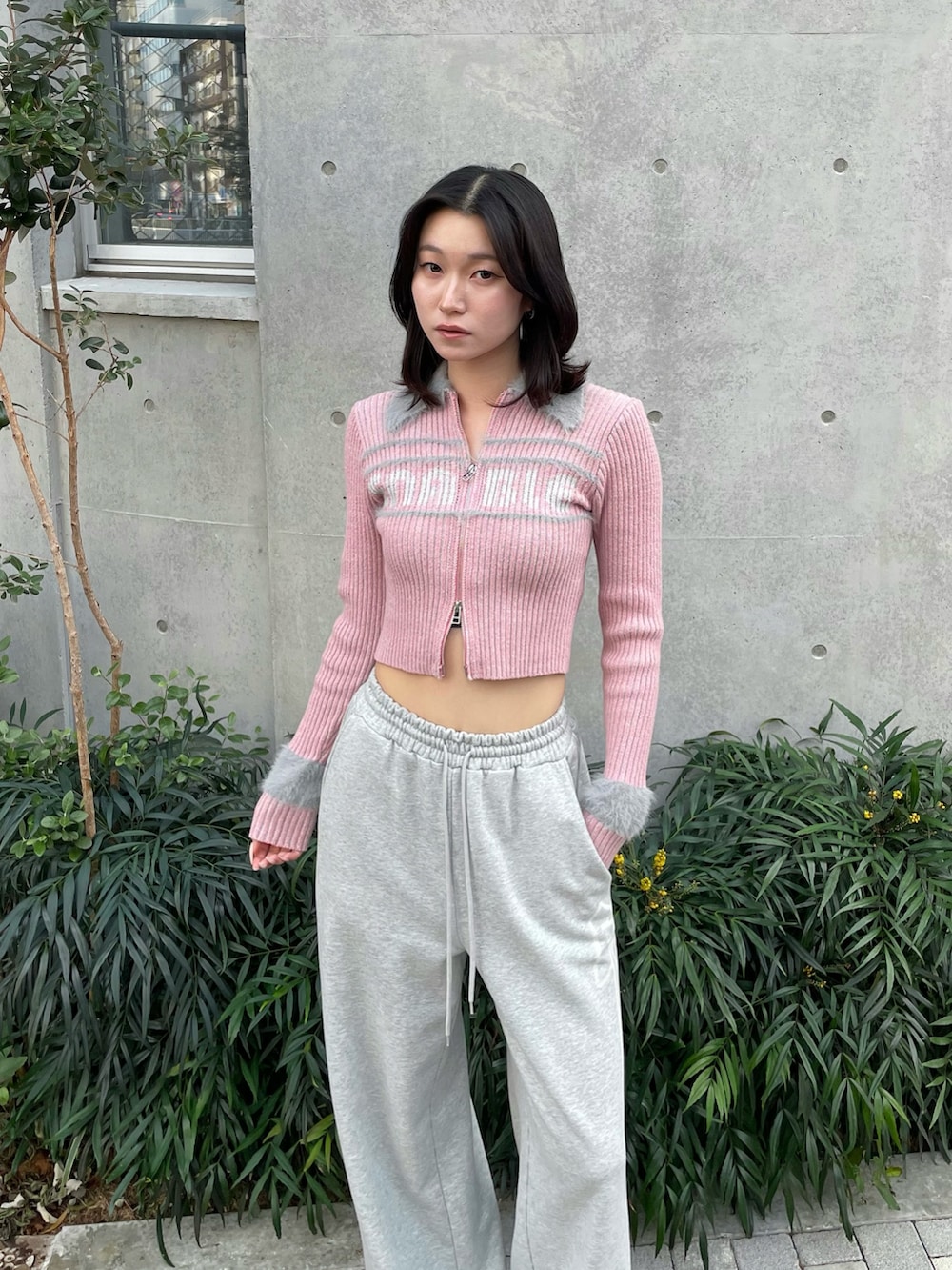 ピンク系のニット/セーター、グレー系のスウェットパンツ、ブラック系のブーツを着用したレディースの冬コーディネートの2枚目の写真