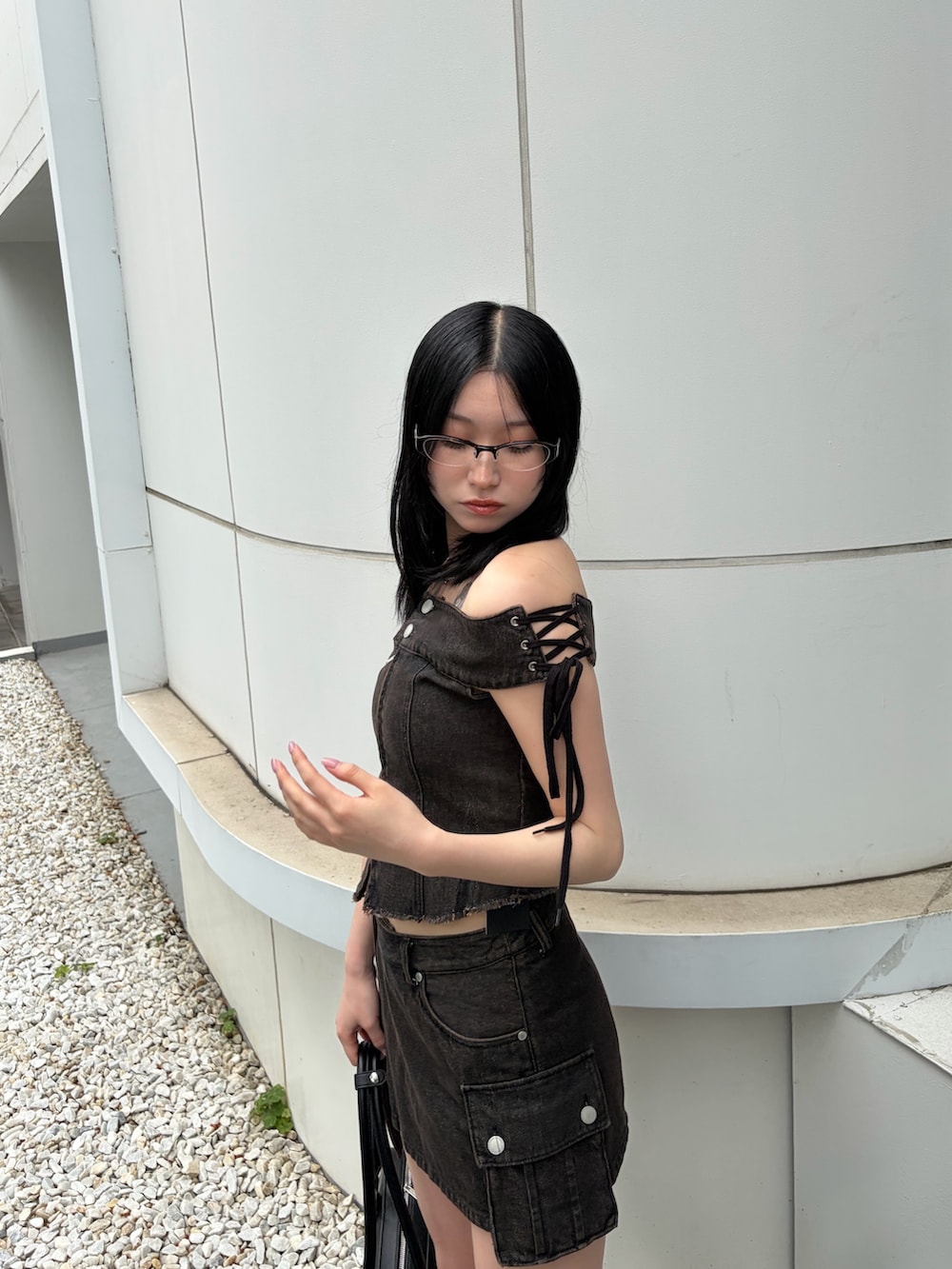 ブラック系のハンドバッグ、ブラウン系のTシャツ/カットソー、ブラウン系のスカートを着用したレディースの春コーディネートの4枚目の写真
