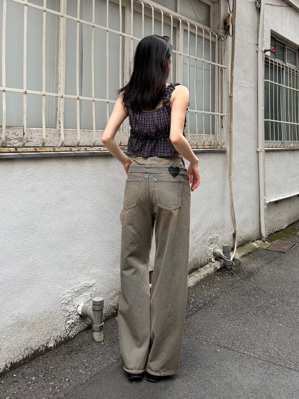 ブラウン系のタンクトップ、ブラウン系のデニムパンツ、ブラック系のサンダルを着用したレディースの夏コーディネートの3枚目の写真