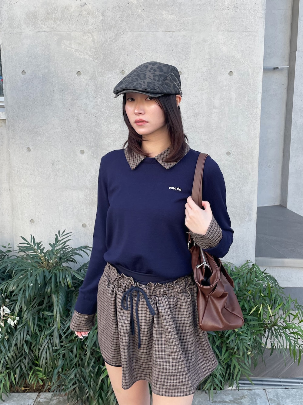 ブルー系のスカート、ブラック系のトートバッグ、ブラウン系のブーツを着用したレディースの冬コーディネートの5枚目の写真