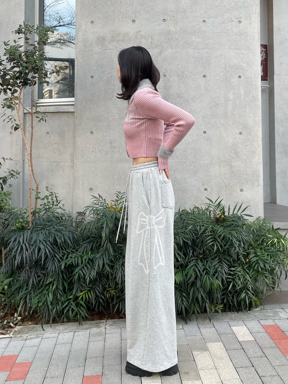 ピンク系のニット/セーター、グレー系のスウェットパンツ、ブラック系のブーツを着用したレディースの冬コーディネートの3枚目の写真